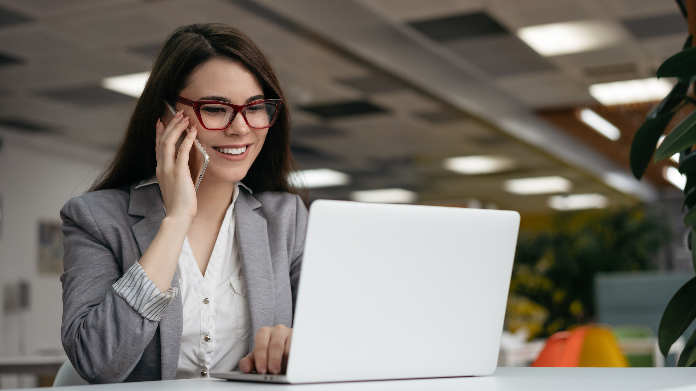 A woman on the phone while working from her laptop