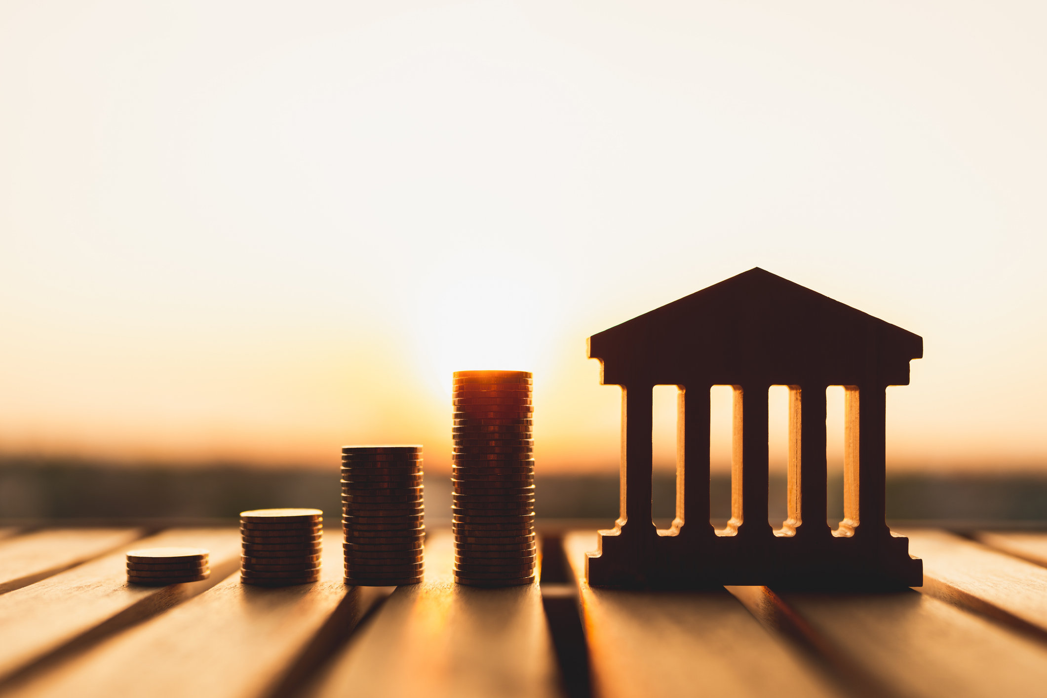 Coins stacked leading to the front of a bank